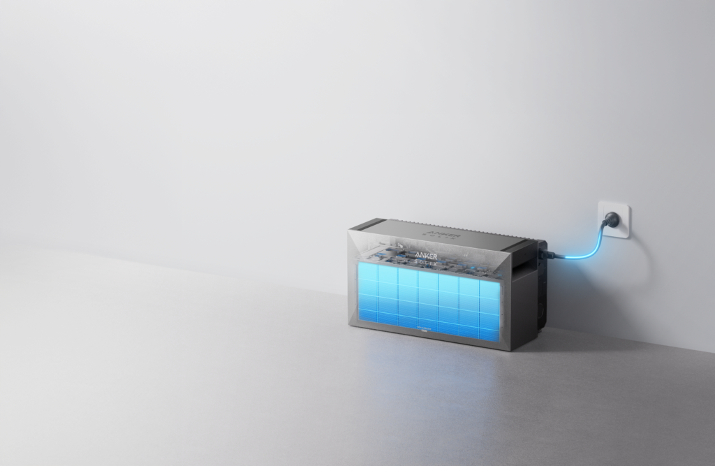 Anker Solix home battery with visible blue Samsung 21700 lithium-ion cells, plugged into a wall outlet with a glowing blue power cord against a light background